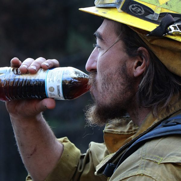 Firefighter rehydrating during a break from firefighting operations
