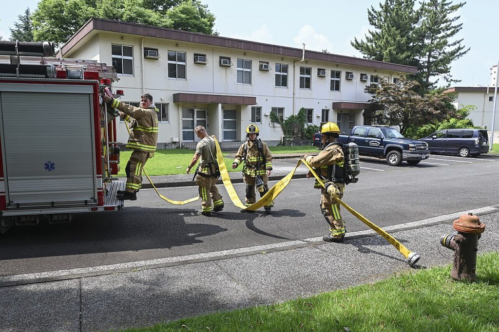 Firefighters advancing a hose line during structure fire training