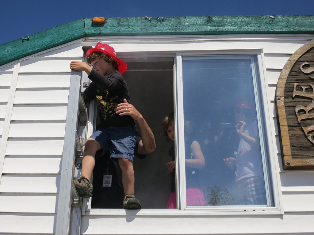 Person practising a window escape during a fire safety exercise